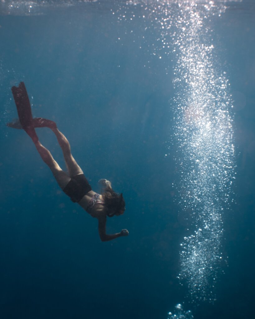 A freediver is checking bubbles coming from the scuba divers in the sea, in Tubod Marine Sanctuary.
